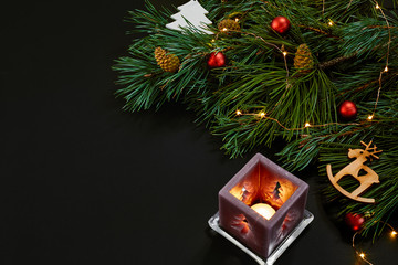 Christmas. Xmas toys and spruce branch on black background top view. Space for text