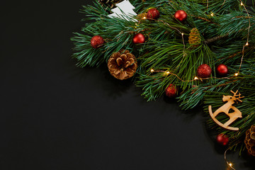 Christmas. Xmas toys and spruce branch on black background top view. Space for text