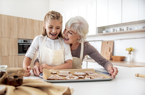 Joyful granny and child are satisfied with self-made pastry
