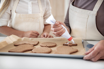 Skillful female arms decorating self-made cookies