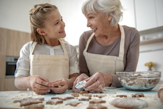 Happy girl and granny having fun in kitchen