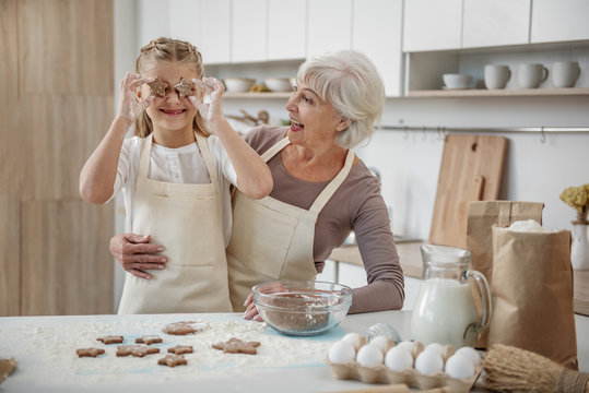 Joyful granny and child are having fun in the kitchen
