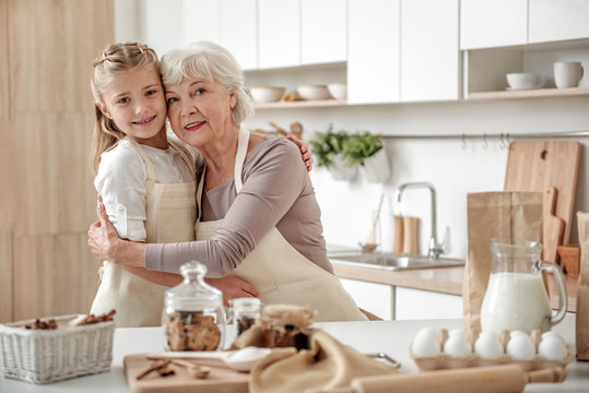 Joyful old woman and granddaughter are ready to cook together