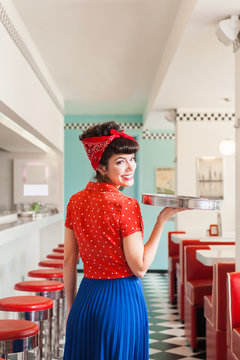 Handsome rockabilly  pun up waitress serving at vintage cafe.