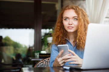 Young redhead girl texting message during lunch