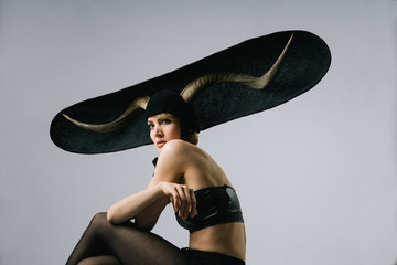 Portrait of a feminine fashion model wearing extravagant hat with horns