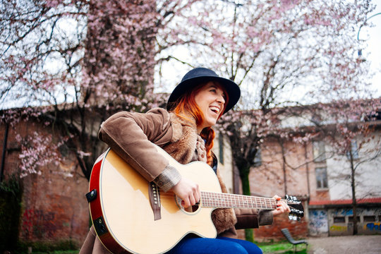 Musician playing guitar in a park in spring