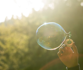 girl blows one big soap bubble