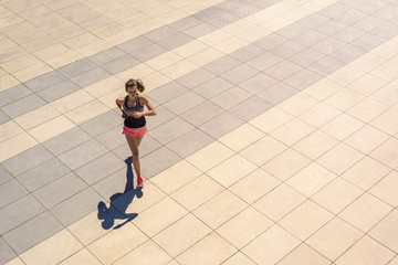 Young fit woman running in sunny day in the city fill active girl.