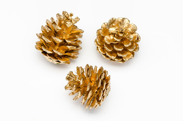 three golden pine cone on a white background