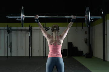 Fit woman holding a weight in the gym