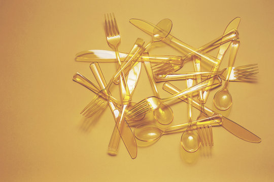 Yellow cutlery sit in centre of yellow background...