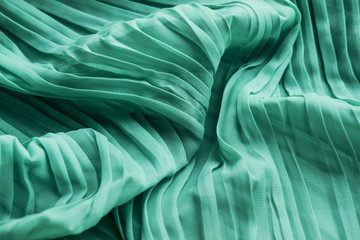 Obraz premium The texture of the mint pleated fabric. Green georgette fabrics.