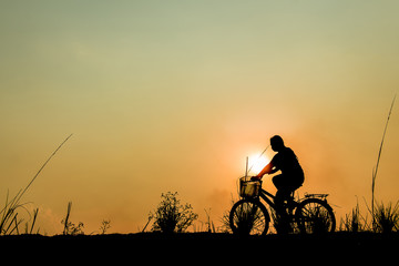 silhouette of a girl riding on a trail with his bike.