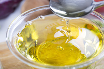 Spoon with virgin olive oil and fresh vegetables.