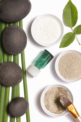 Obraz na płótnie Canvas White and green cosmetic clay beside zen stones, natural cosmetics products concept 