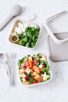 Traditional healthy Panzanella salad with fresh tomatoes and crispy bread in a lunchbox Top view