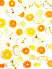 Food pattern of fresh fruit in a cut. Oranges, lemons, bananas, apples, tangerines slices. Top view, flat lay. Citrus fruits  background, wallpaper.