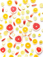 Food pattern of fresh fruit in a cut. Oranges, grapefruit, lemons, bananas, apples tangerines slices. Top view, flat lay. Citrus fruits  background, wallpaper.