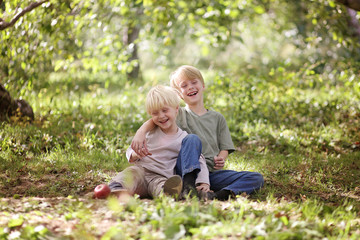 Naklejka na ściany i meble Two Happy Children Laughing Outside in the Forest