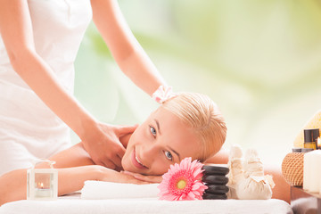 Young smile beautiful blonde woman lying on a massage table and having massage.
