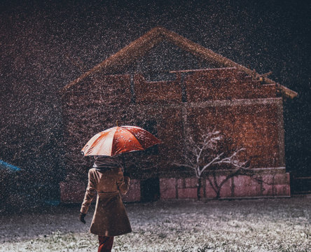 young girl with umbrella outdoors In snowfall