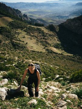 Girl climbing a rock in sunny el chorro