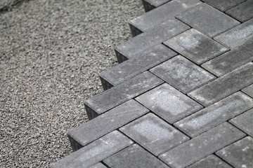Gray cement bricks  and little stones building a floor.