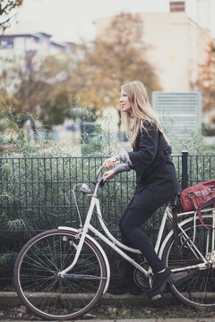 Pretty blond girl on a white bicycle