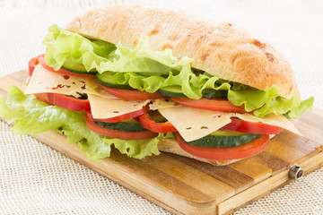 Ciabatta Sandwich with cheese on cutting board
