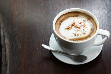 Coffee in a white cup on an old wooden table.
