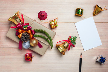 Christmas gift box,paper note,pencil and new year decoration on wood plate.Flat lay.Christmas and New year concept.