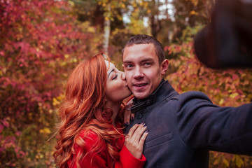 Couple taking selfie in autumn forest