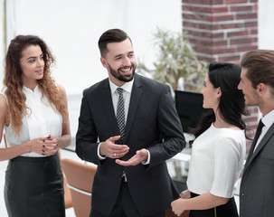 smiling business team talking, standing in office