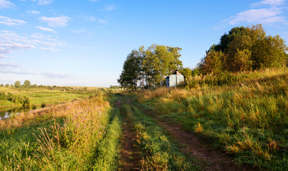 Naklejka premium Sunny summer landscape with ground countryside road