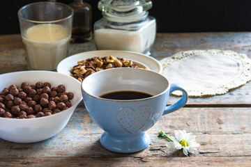 on the table a cup with a hot drink and cornflakes