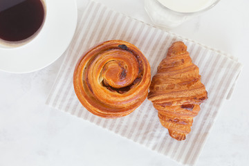 French croissant with coffee and a glass of milk on the table top view. European breakfast