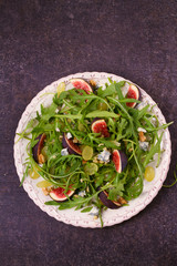 Grapes, figs, blue cheese, arugula and walnuts salad. View from above, top studio shot, vertical