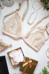 Beige lace bra on the white Christmas background. Fashion accessories as New Year gift.