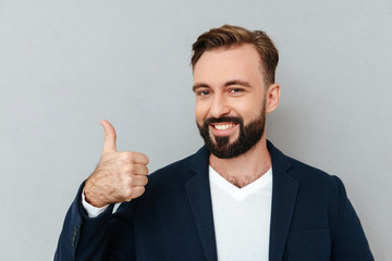 Cheerful bearded man in business clothes showing thumb up