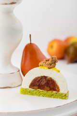 Cut vanilla mousse pastry dessert with caramelized pear