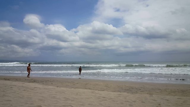 Woman passing by on beach of Kuta, Bali