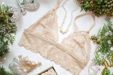 Beige lace bra on the white Christmas background. Fashion accessories as New Year gift.