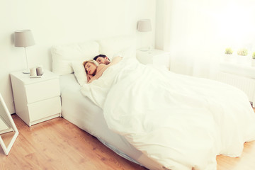Fototapeta na wymiar happy couple sleeping in bed at home
