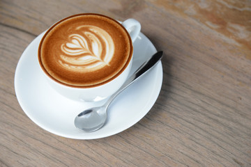 coffee cup of latte art with hearth shape for coffee break or breakfast on wooden table