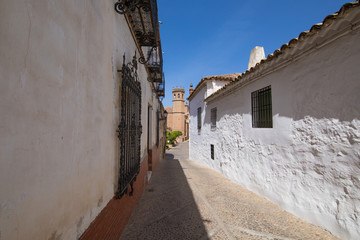 Fototapeta na wymiar landmark ancient street and bell tower in old town of Banos de la Encina village, in Jaen, Andalusia, Spain Europe 