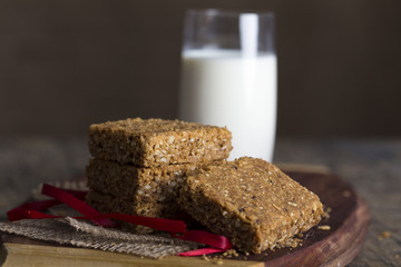 Stack of oatmeal crunchy cookies and milk in background