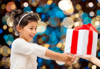 Fototapeta na wymiar smiling little girl giving or receiving present