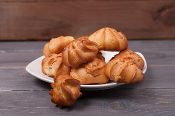 Fresh fragrant tasty biscuits on a white plate against the background of a table made of old wood