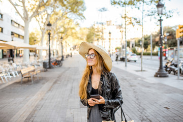 Young woman tourist in hat walking on the famous pedestrian boulevard in Barcelona city